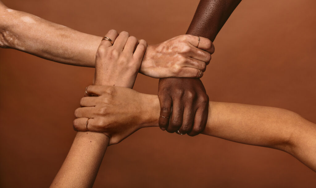 Four women hold each other's wrists forming a circle in this picture -- and a show of unity.