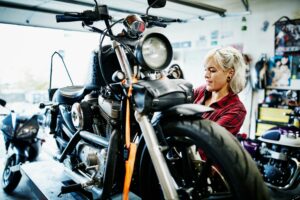 A mechanic is pictured here chaning the oil on her motorcycle. May is National Motorcylce Safety Awareness Month.