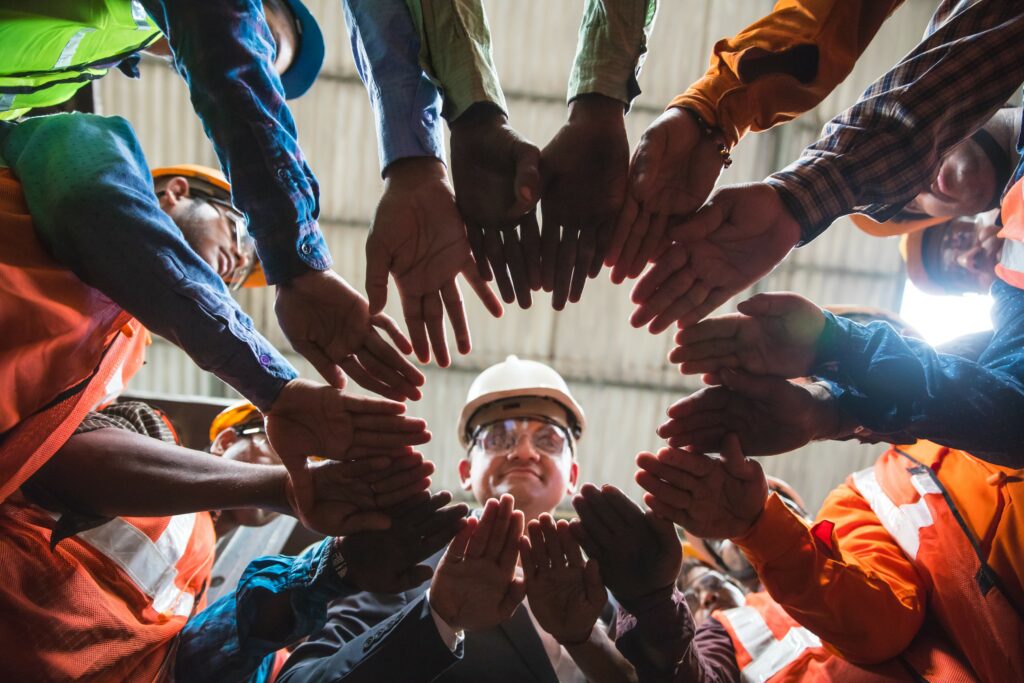 A workplace team circles up, hands in and then breaks for safety.
