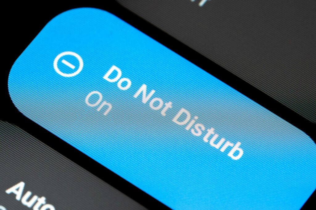 This is a photograph of a smartphone with the "do not disturb" message displaying on the screen.
