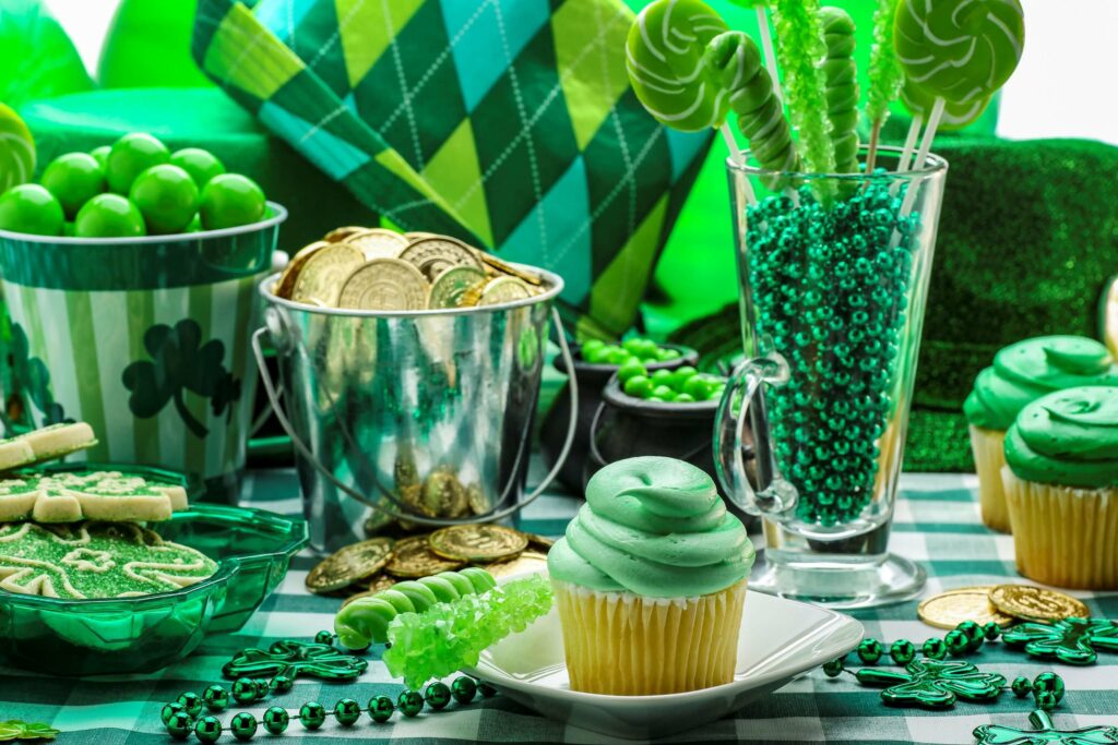 This is a photograph of a St. Patrick's Day table decked out with party favors and green-frosted cupcakes.