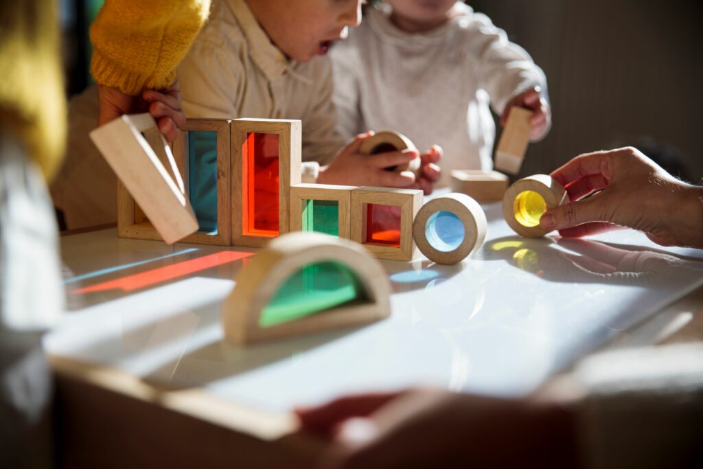 Infants are pictured here playing with wooden blocks. Use safety building blocks to keep kids safe.