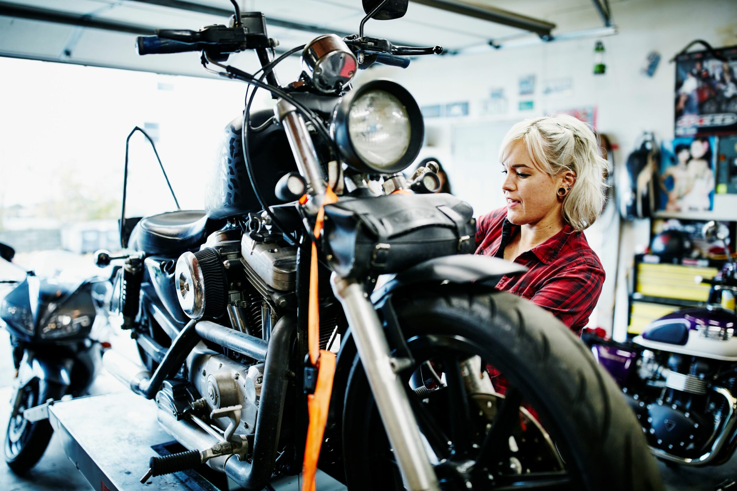 A mechanic is pictured here chaning the oil on her motorcycle. May is National Motorcylce Safety Awareness Month.