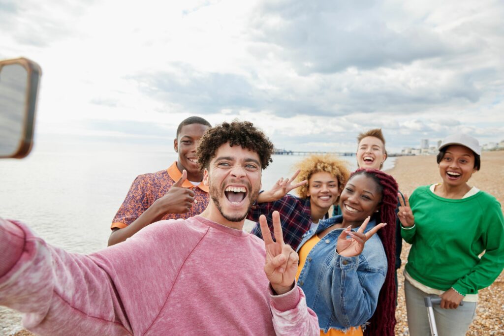 A group of teens gather here and pose for a selfie on the beach. May is Global Youth Traffic Safety Month.