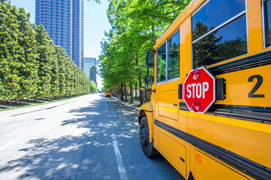 A school bus in Dallas is parked next to the curb as the driver waits for students to be dismissed from class.