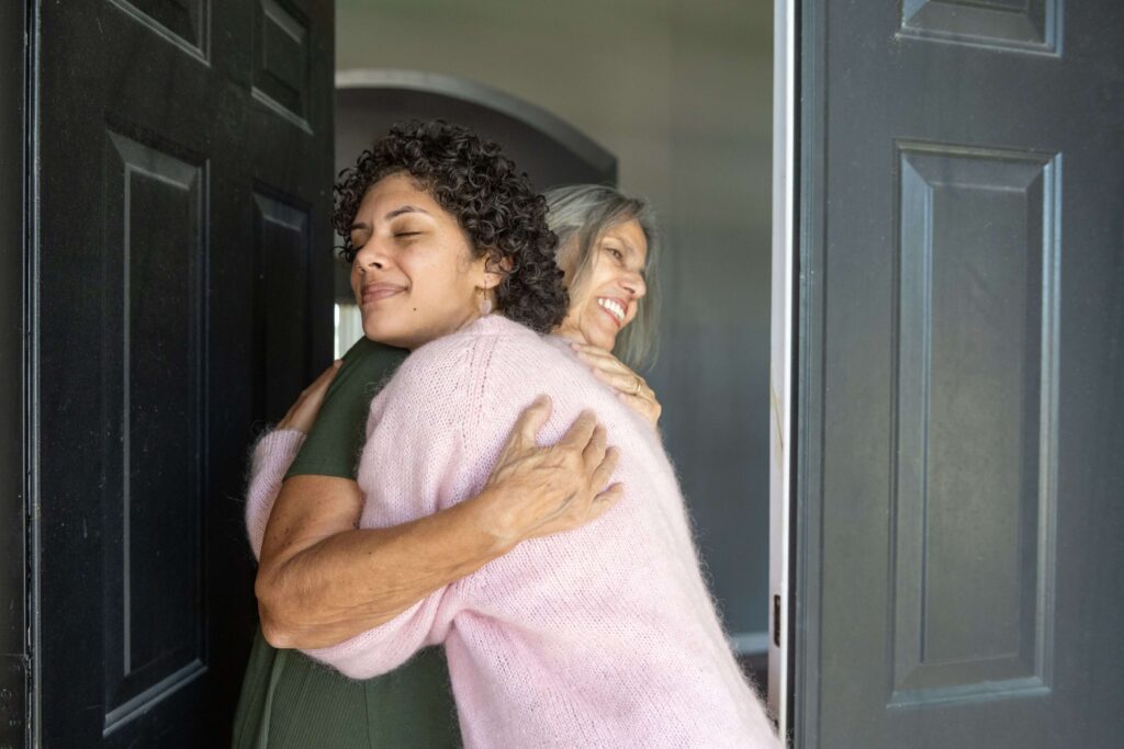 Grandma greeting: A mom embraces her daughter at the front door. The family made the trip to be with relatives at Thanksgiving.