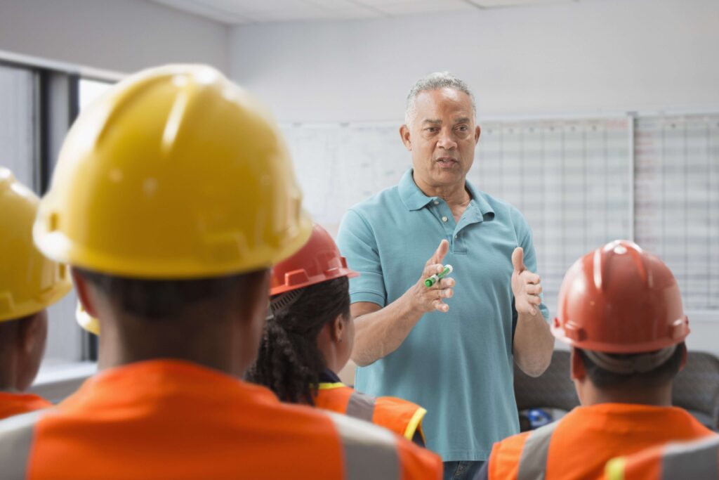 This is a stock image of a safety leader presenting information to his crew.