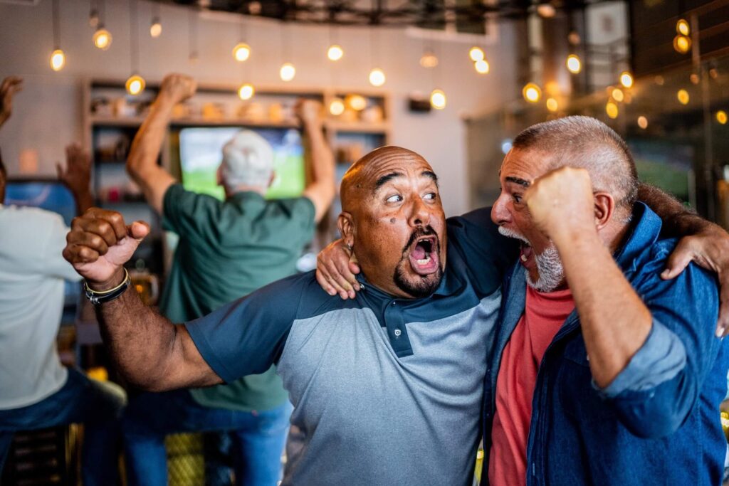 Two fans celebrate here in a scene that will be repeated all across America as friends and family members gather to watch the big game.