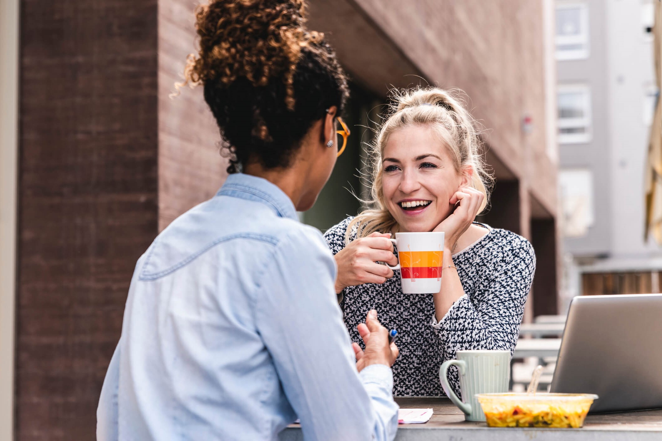 Two coworkers share a smile and a laugh during a break.